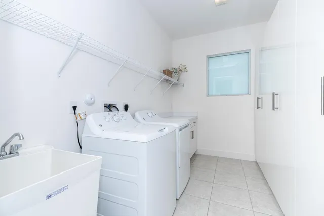 a utility room with cabinets washer and dryer
