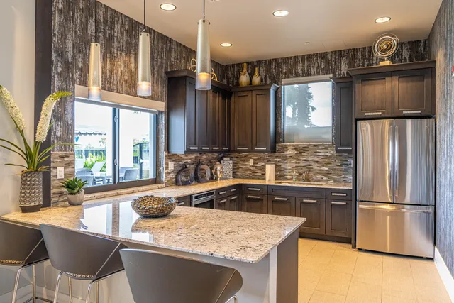 a kitchen with stainless steel appliances granite countertop a sink refrigerator and cabinets