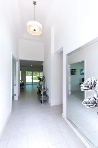 a view of a hallway with livingroom and a chandelier