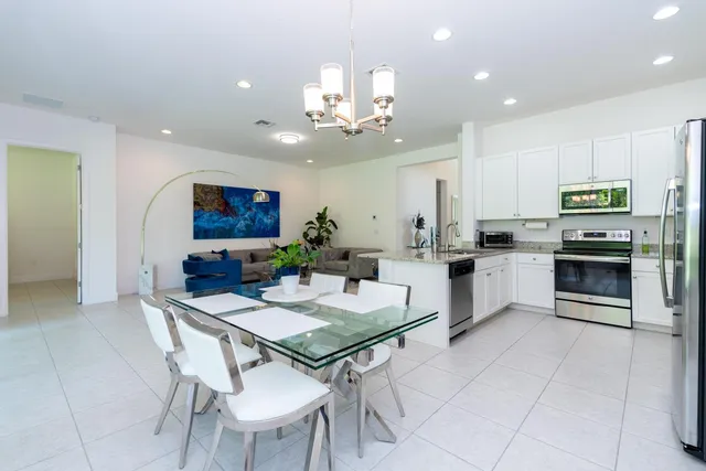 a kitchen with a dining table cabinets appliances and a counter top space