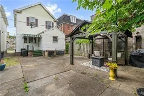 a view of a backyard with table and chairs under an umbrella