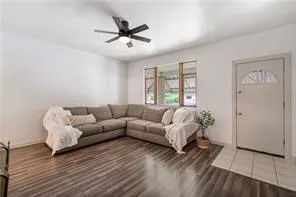 a living room with furniture and a wooden floor
