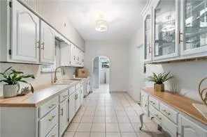 a large kitchen with granite countertop a sink a stove and cabinets