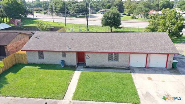 a view of house with backyard and a garden