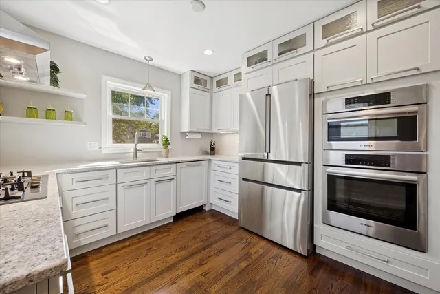 a kitchen with a white cabinets and wooden floor