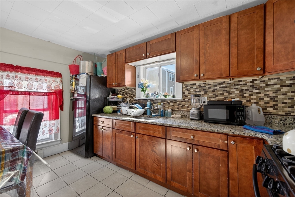 6 Morris Street Lynn, MA 01905 - Photo 17 of 36 a kitchen with stainless steel appliances granite countertop a sink stove and cabinets