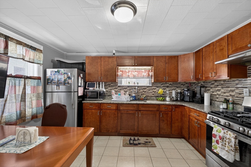 6 Morris Street Lynn, MA 01905 - Photo 5 of 36 a kitchen with stainless steel appliances granite countertop a stove a sink dishwasher a microwave oven with granite countertops and cabinets