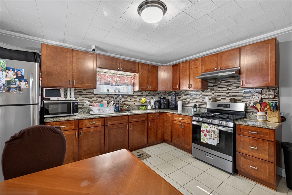 6 Morris Street Lynn, MA 01905 - Photo 6 of 36 a kitchen with stainless steel appliances granite countertop a sink stove and refrigerator