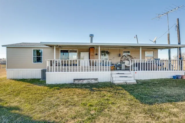 a view of a house with a yard and deck of a house