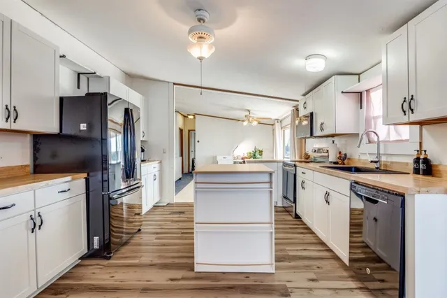 a kitchen with cabinets and wooden floor