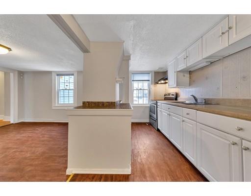 107 Cedar Street Springfield, MA 01105 - Photo 5 of 29 a kitchen with granite countertop a sink cabinets stainless steel appliances and a window