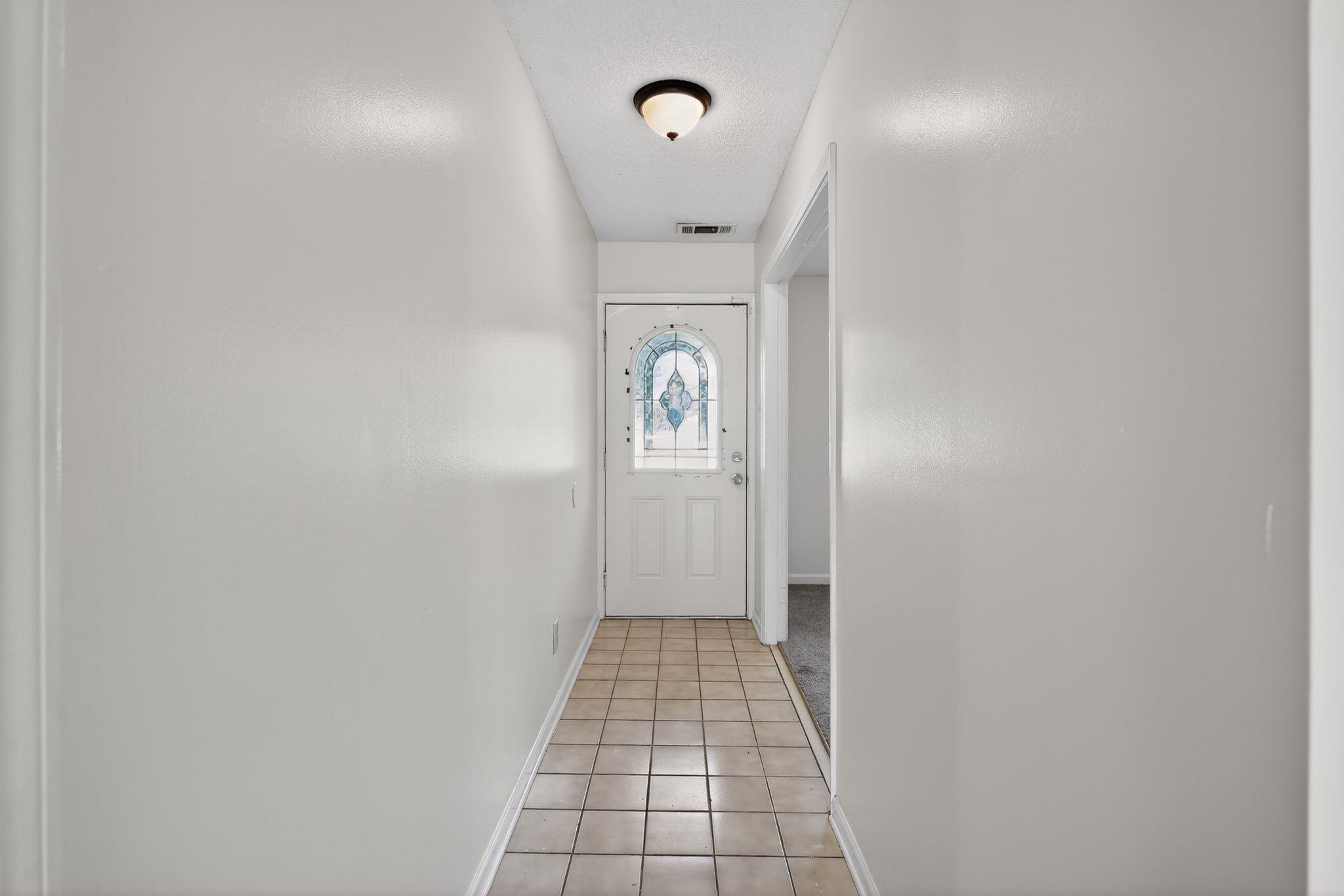 3820 Clarke Road Memphis, TN 38115 - Photo 4 of 30 Doorway to outside featuring baseboards and tile patterned flooring