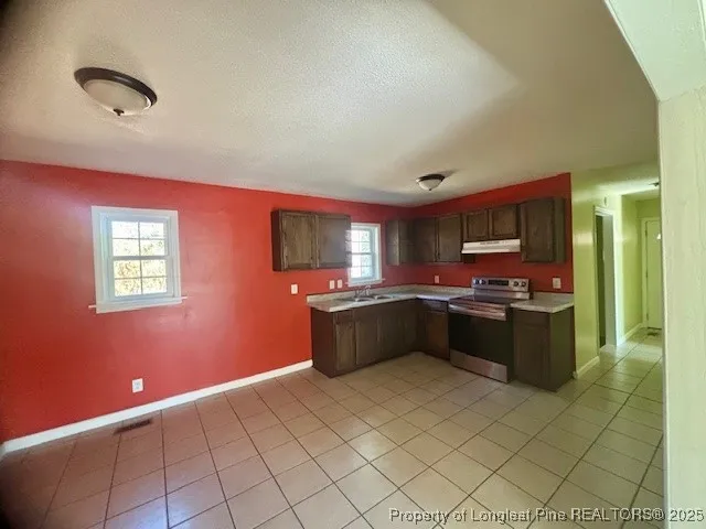 a large kitchen with stainless steel appliances granite countertop a refrigerator and a stove