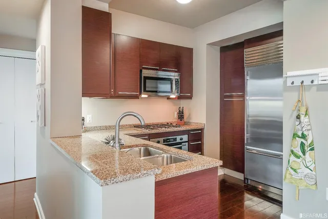 a kitchen with stainless steel appliances granite countertop a sink stove and refrigerator