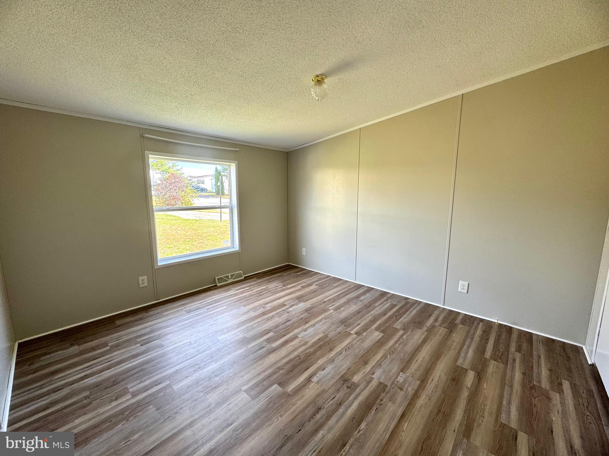 701 Cassel Road, Unit 105 Manchester, PA 17345 - Photo 26 of 35 a view of an empty room with wooden floor and a window
