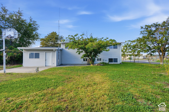 1127 Electra Lane Sandy, UT 84094 - Photo 23 of 27 Expansive green space with mature trees, a paved area, and a basketball hoop