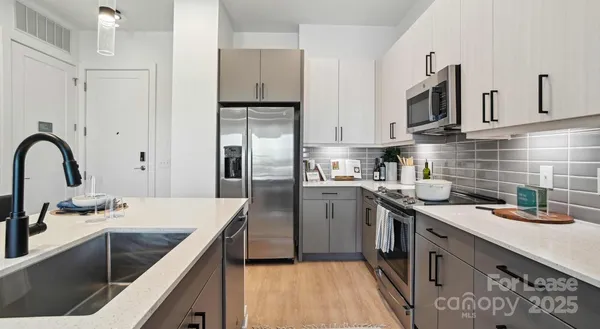 a kitchen with stainless steel appliances granite countertop a sink stove and refrigerator