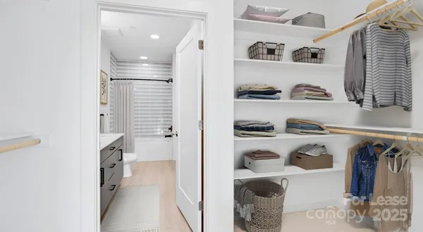 a view of walk in closet with clothes and shoes