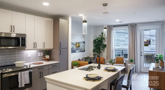 a kitchen with a stove a sink dishwasher a microwave oven and a dining table with wooden floor