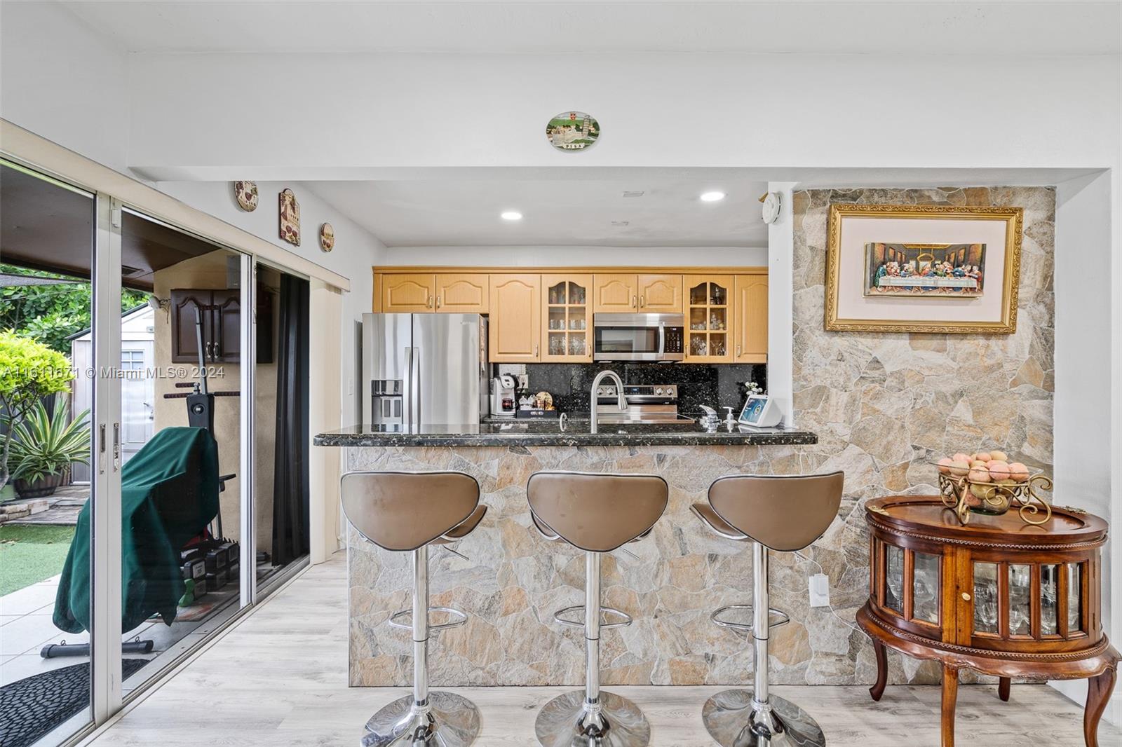 11914 Southwest 125th Place Miami, FL 33186 - Photo 11 of 31 a kitchen with stainless steel appliances granite countertop a stove a refrigerator a kitchen island a dining table and chairs