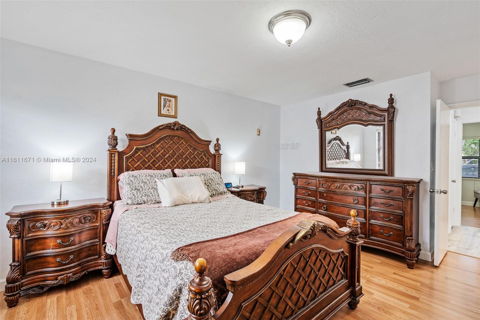 11914 Southwest 125th Place Miami, FL 33186 - Photo 17 of 31 a bedroom with a bed and wooden floor