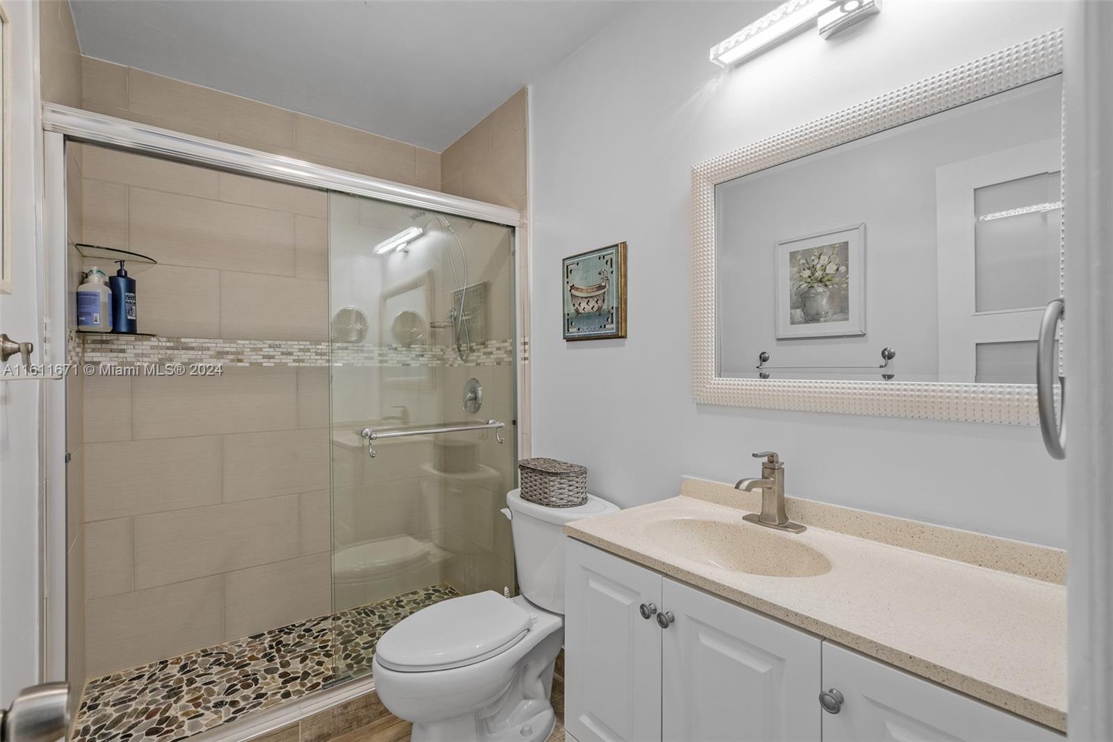 11914 Southwest 125th Place Miami, FL 33186 - Photo 19 of 31 a bathroom with a sink toilet a mirror and shower
