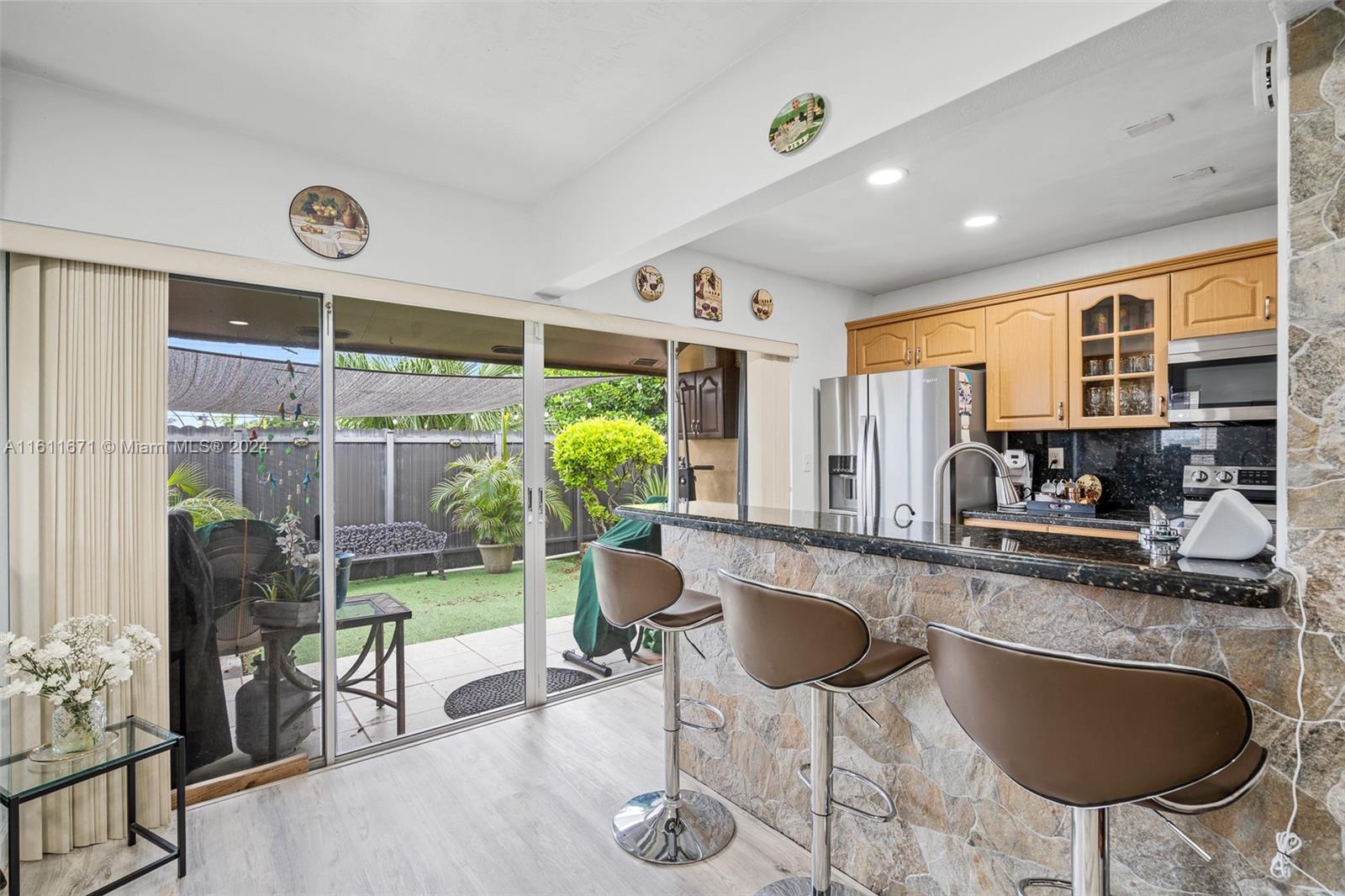 11914 Southwest 125th Place Miami, FL 33186 - Photo 10 of 31 a kitchen with sink refrigerator dining table and chairs