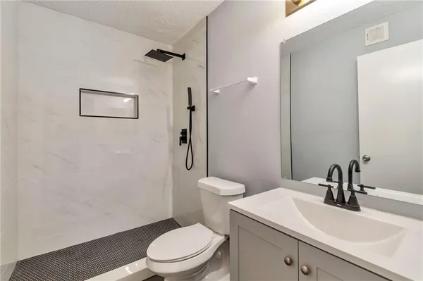 a bathroom with a sink a toilet and shower
