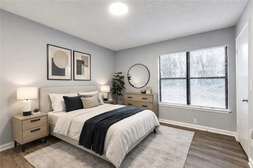 1502 Huntingdon Chase Atlanta, GA 30350 - Photo 15 of 29 a bedroom with a large bed and wooden floor