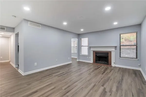 an empty room with wooden floor and fireplace