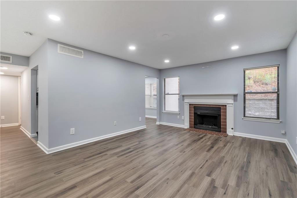 1502 Huntingdon Chase Atlanta, GA 30350 - Photo 4 of 29 an empty room with wooden floor and fireplace