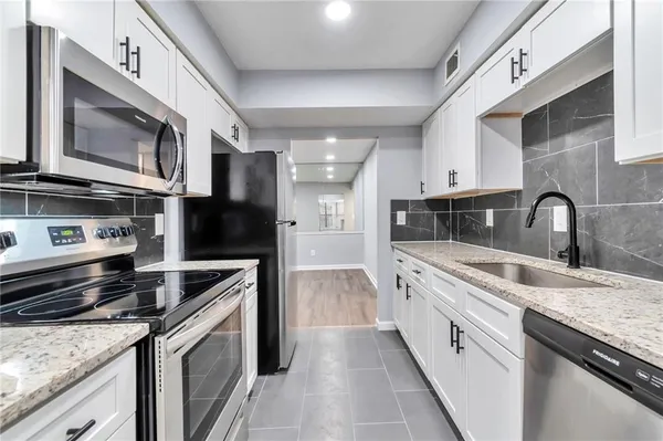 a kitchen with stainless steel appliances granite countertop a stove microwave and sink
