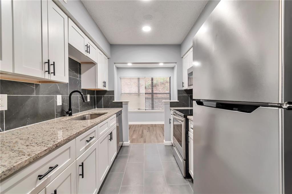 1502 Huntingdon Chase Atlanta, GA 30350 - Photo 8 of 29 a kitchen with a refrigerator and a sink