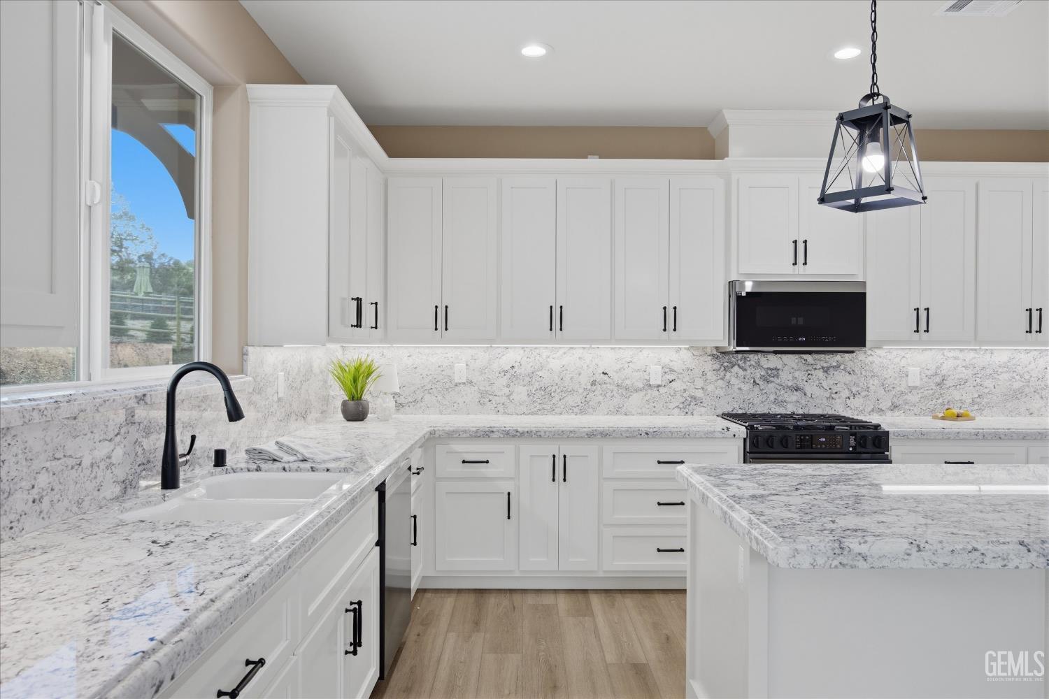Undisclosed Address Tehachapi, CA 93561 - Photo 25 of 47 a kitchen with granite countertop a sink stainless steel appliances and white cabinets