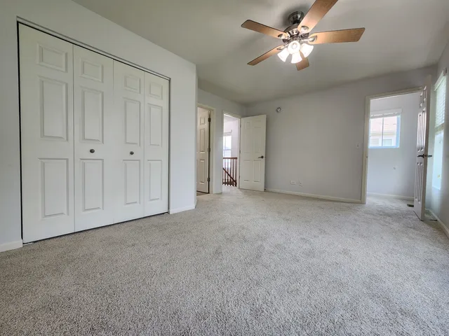 a view of a big room with chandelier fan and closet area