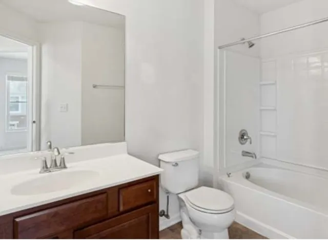 a bathroom with a sink toilet vanity and shower