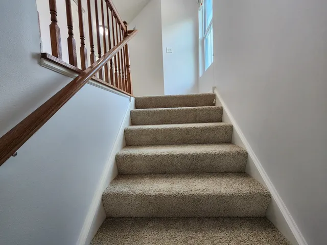 a view of staircase with white walls and a window