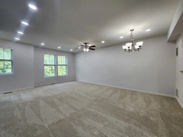 an empty room with stairs and windows