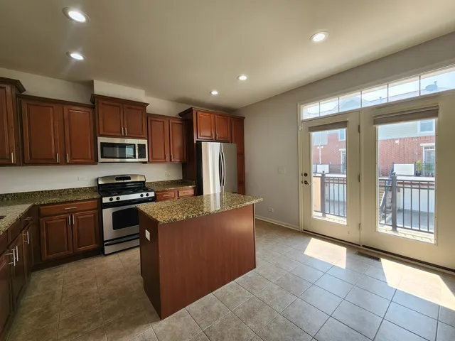 a kitchen with stainless steel appliances granite countertop a stove top oven a sink dishwasher a refrigerator and a oven