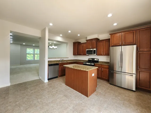 a kitchen with stainless steel appliances granite countertop a refrigerator a sink and a stove