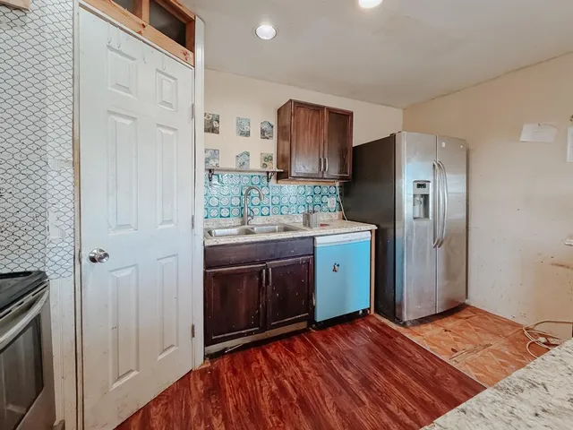 a kitchen with stainless steel appliances granite countertop a refrigerator and a stove top oven