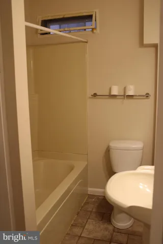 a white toilet sitting next to a bath tub