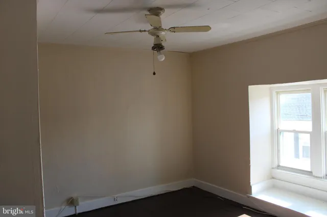 a small space with a window and a fan