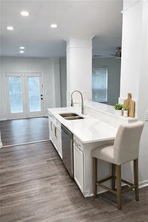 a large white kitchen with sink and island