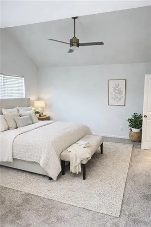 a bedroom with a bed and a potted plant on dresser