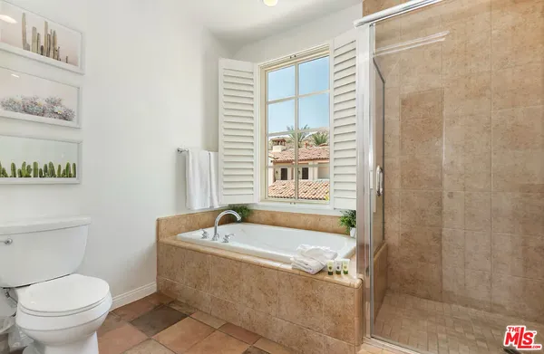 a bath tub sitting next to a white toilet and a shower