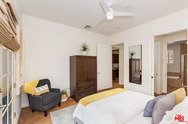 a bedroom with a bed and dresser with mirror