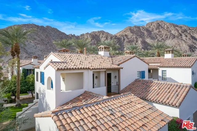 a aerial view of a house with a yard and balcony