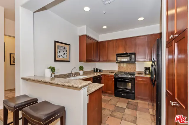 a kitchen with stainless steel appliances granite countertop a stove refrigerator sink and microwave