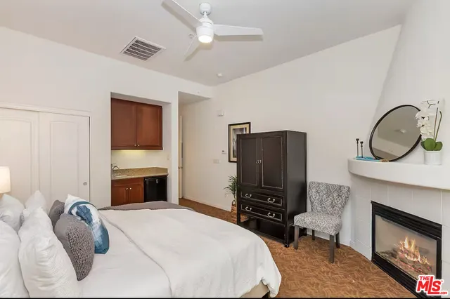 a bedroom with a bed a fireplace and a television